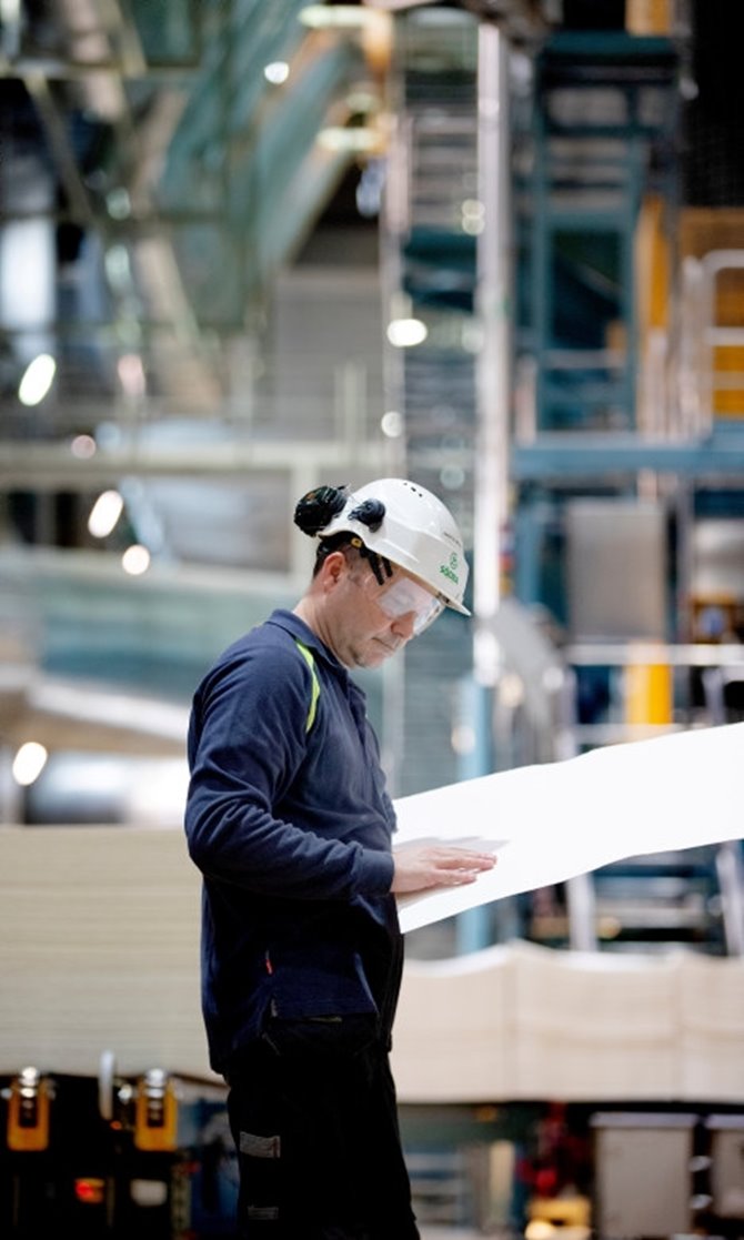 Narcis Mesic studerar ett ark vid torkmaskinen Innovation & Nya affärer Värö