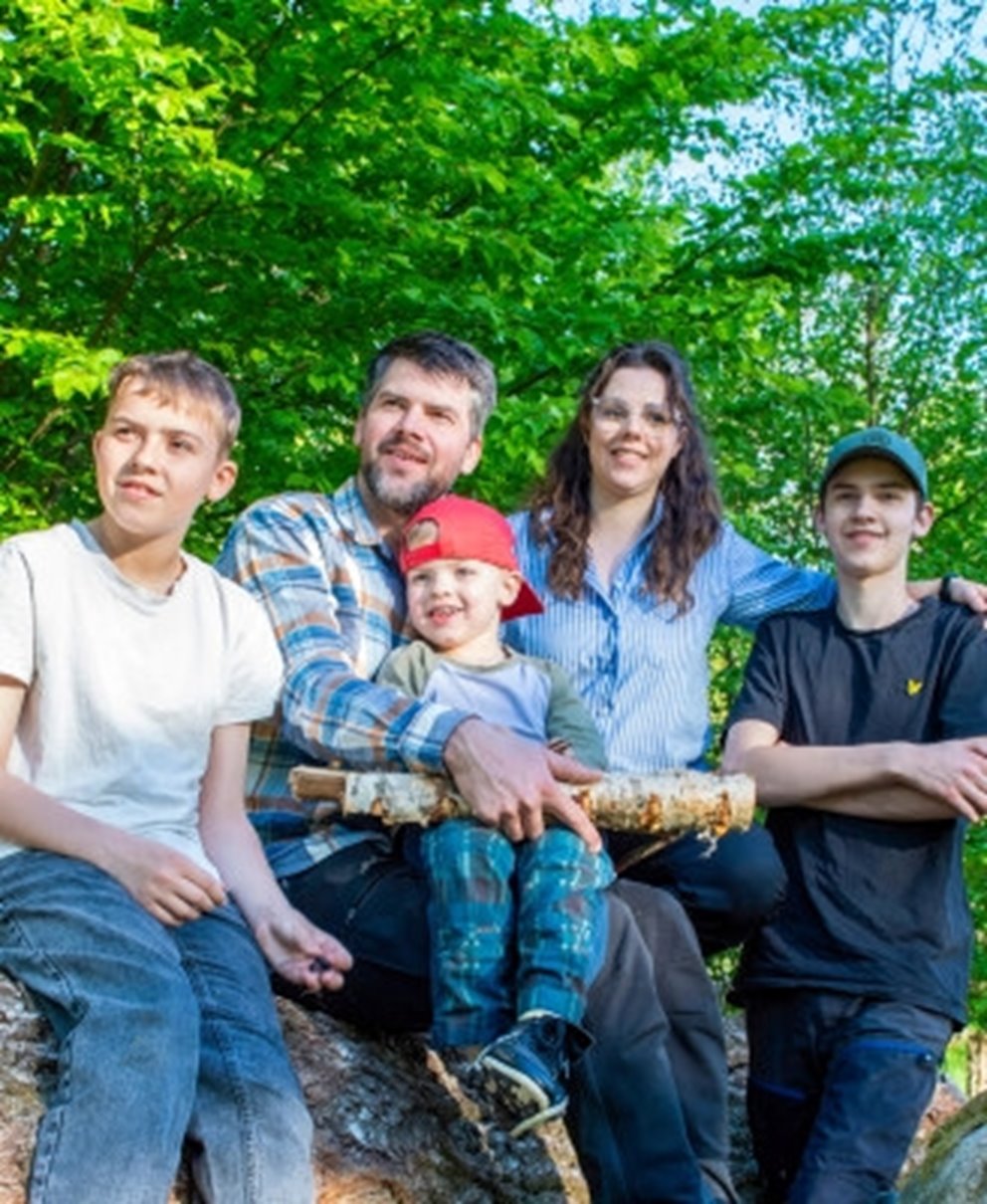 Familj sittandes på trästock