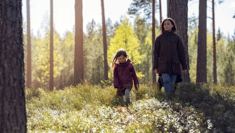 Barn och mamma är ute och går i skogen