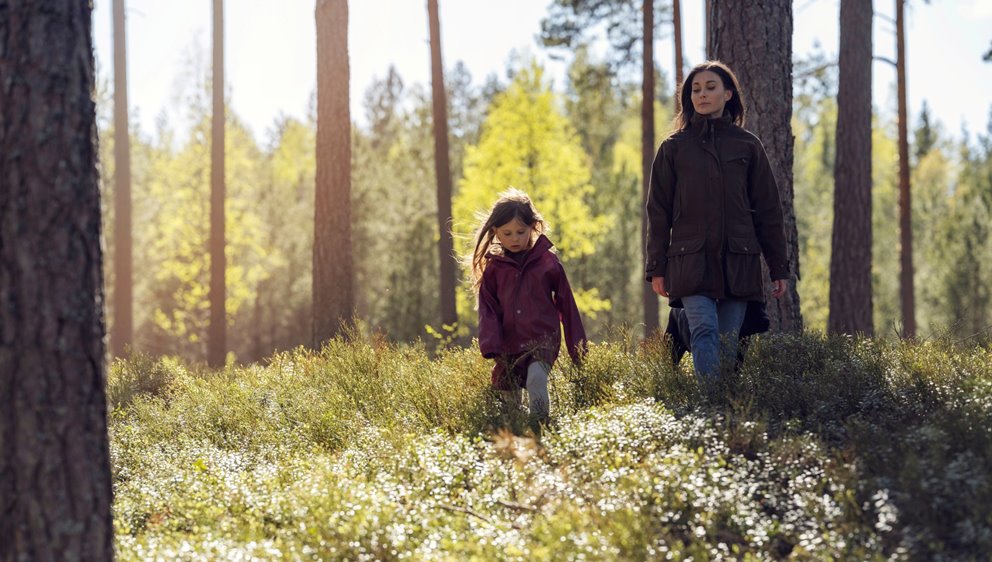 Barn och mamma är ute och går i skogen