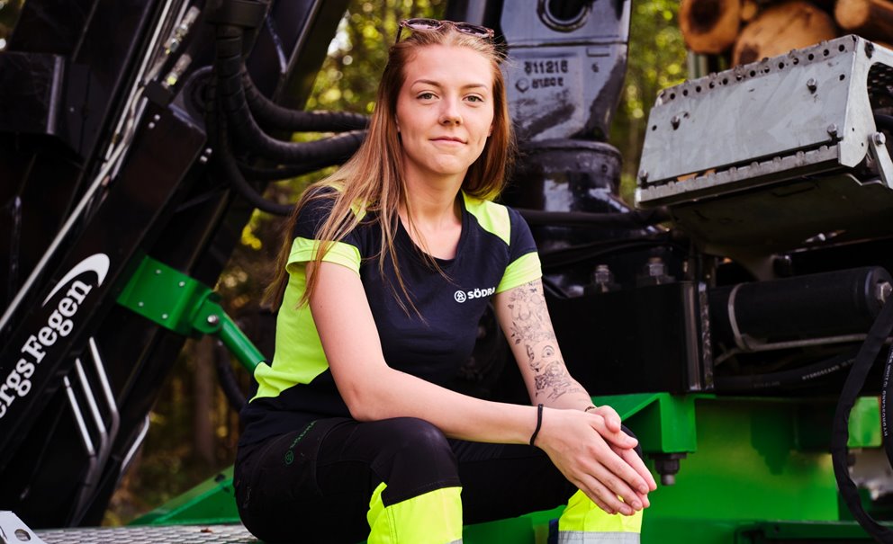 Woman working as a lumberjack sits down and looks at the camera