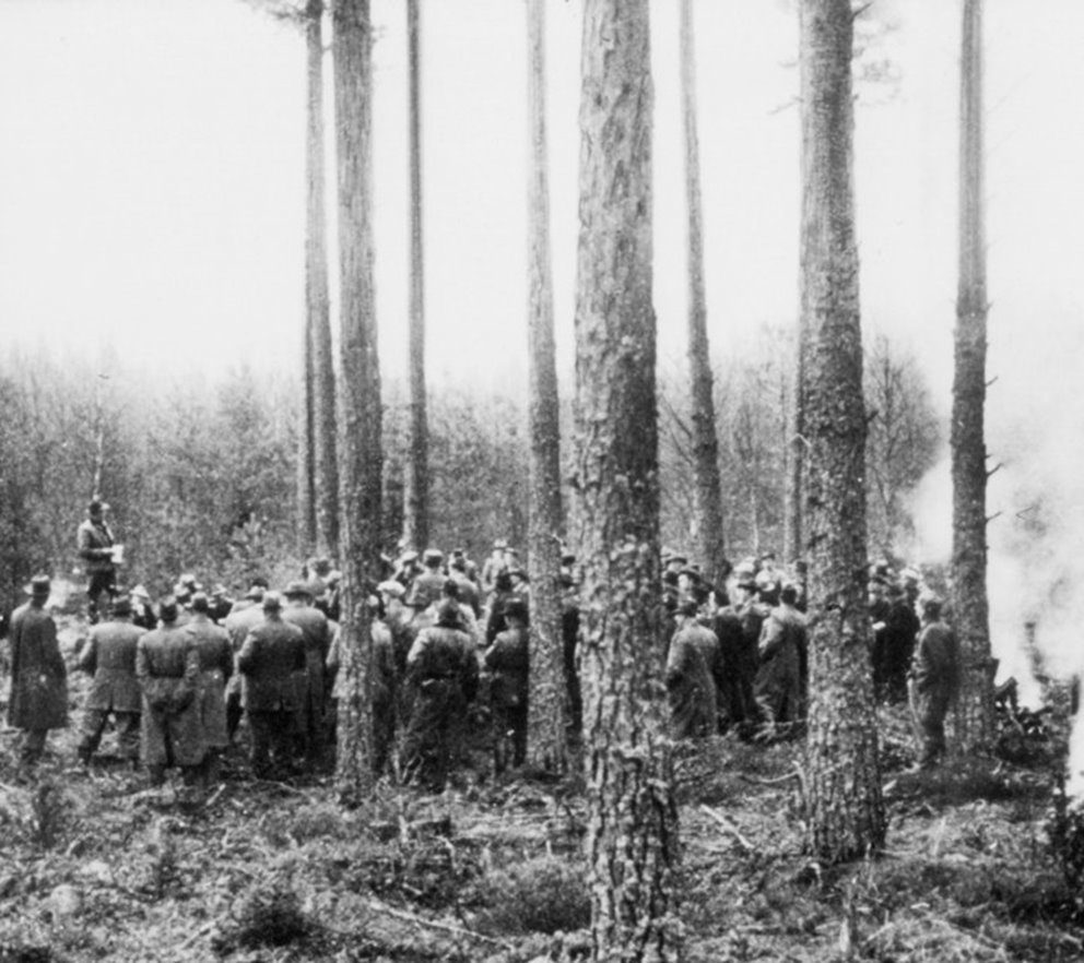 Samling av personer i skogen, någon håller anförande. Omskannad _342.