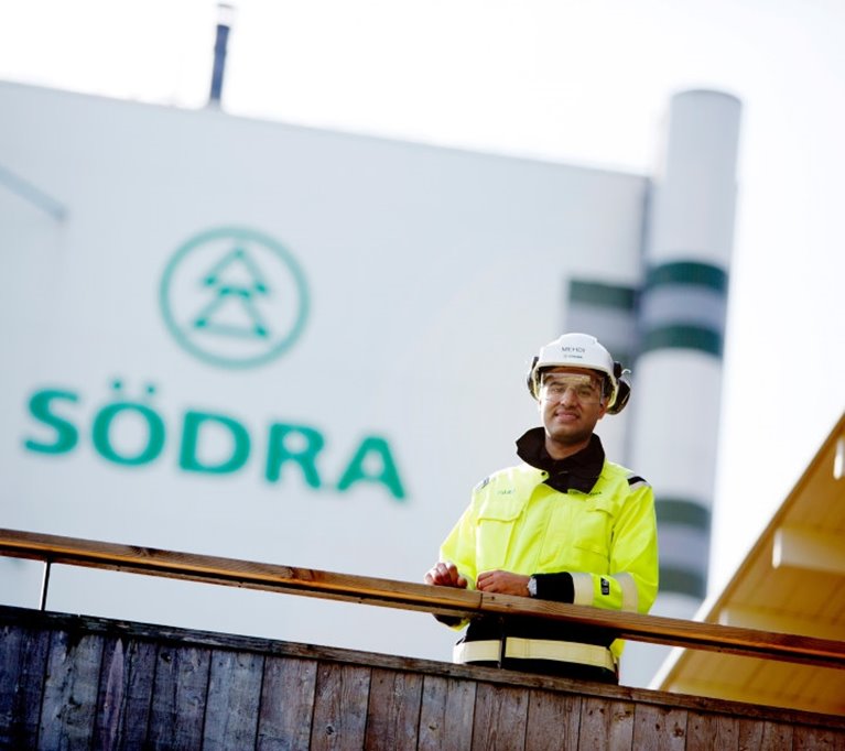 Medarbetare i skyddsutrusting framför Södras anläggning