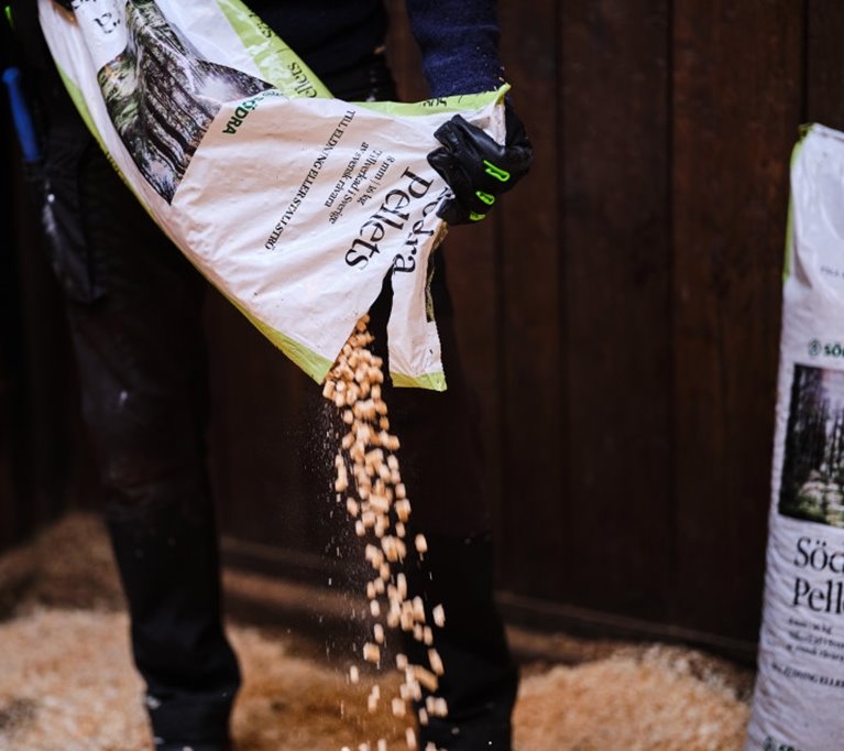 Stallströ sprids av person i hästbox