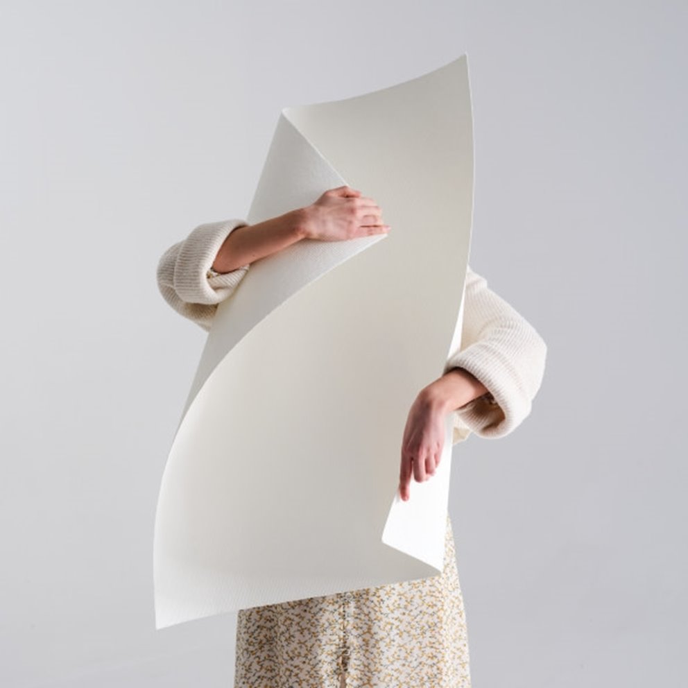 Kvinna håller stort pappermassaark