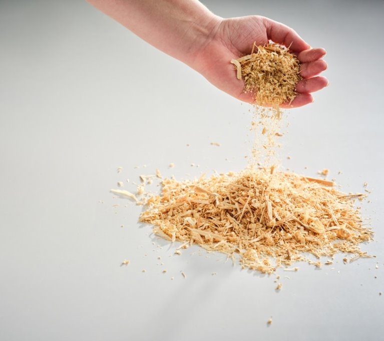 sågspån hälls från hand