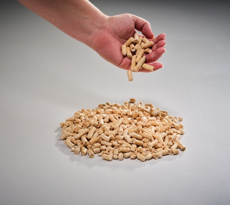 Person häller pellets från handen