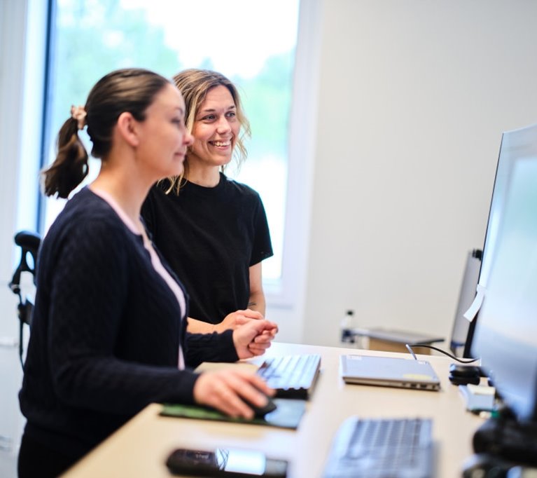 Två kvinnliga Södra medarbetare arbetar framför dator