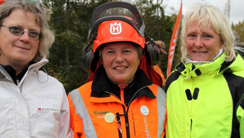 Närbild på tre kvinnor i skogen.