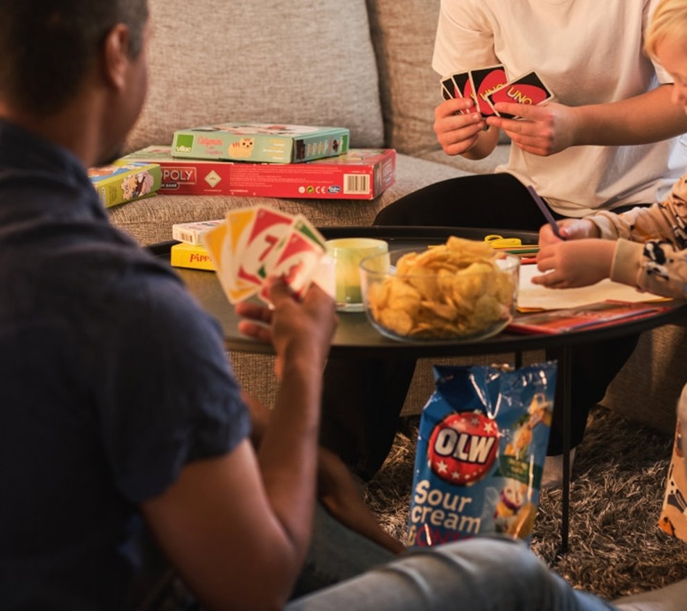 Familj spelar kort och äter chips