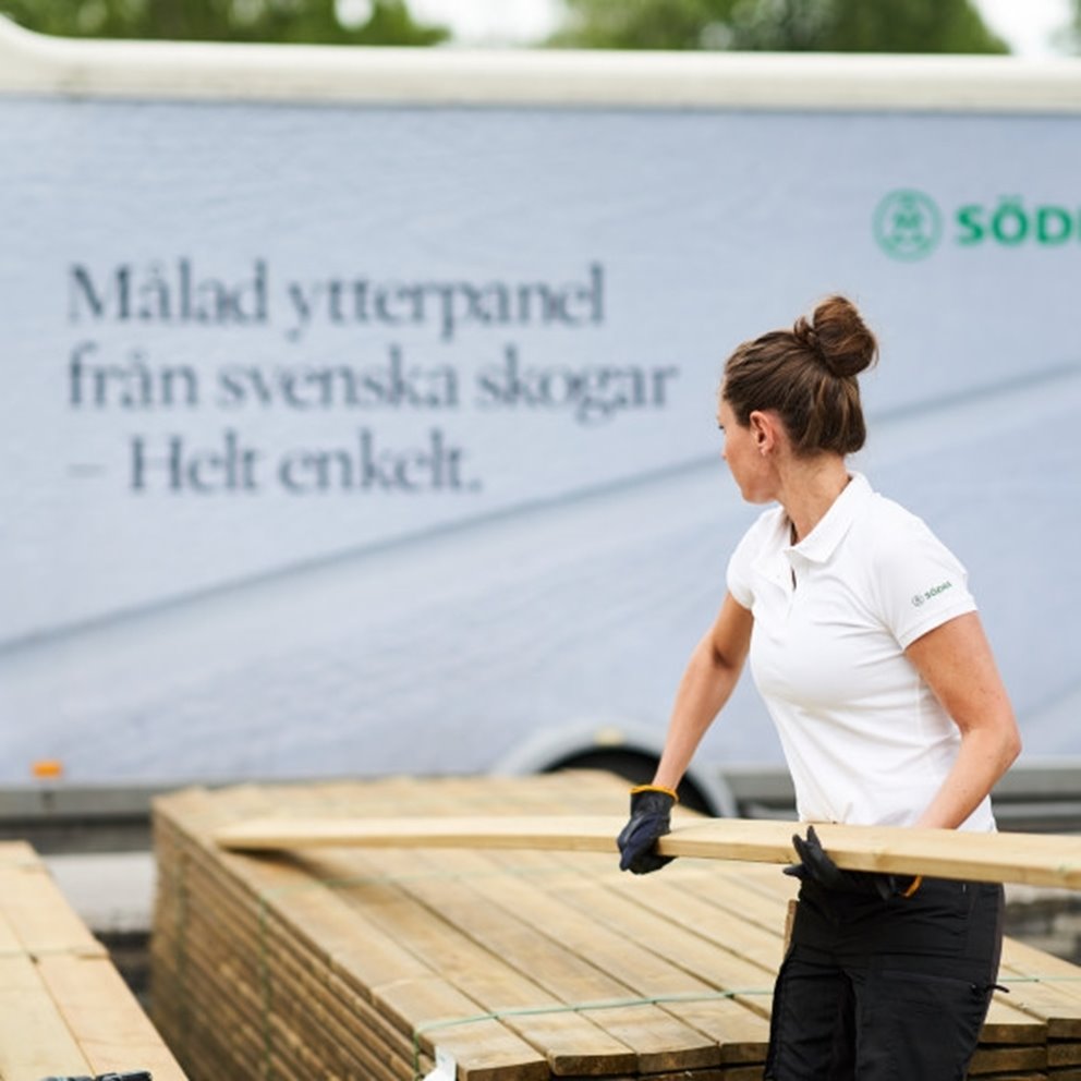 Kvinna plockar tryckimpregnerad trall 28x120 mm släp i bakgrunden