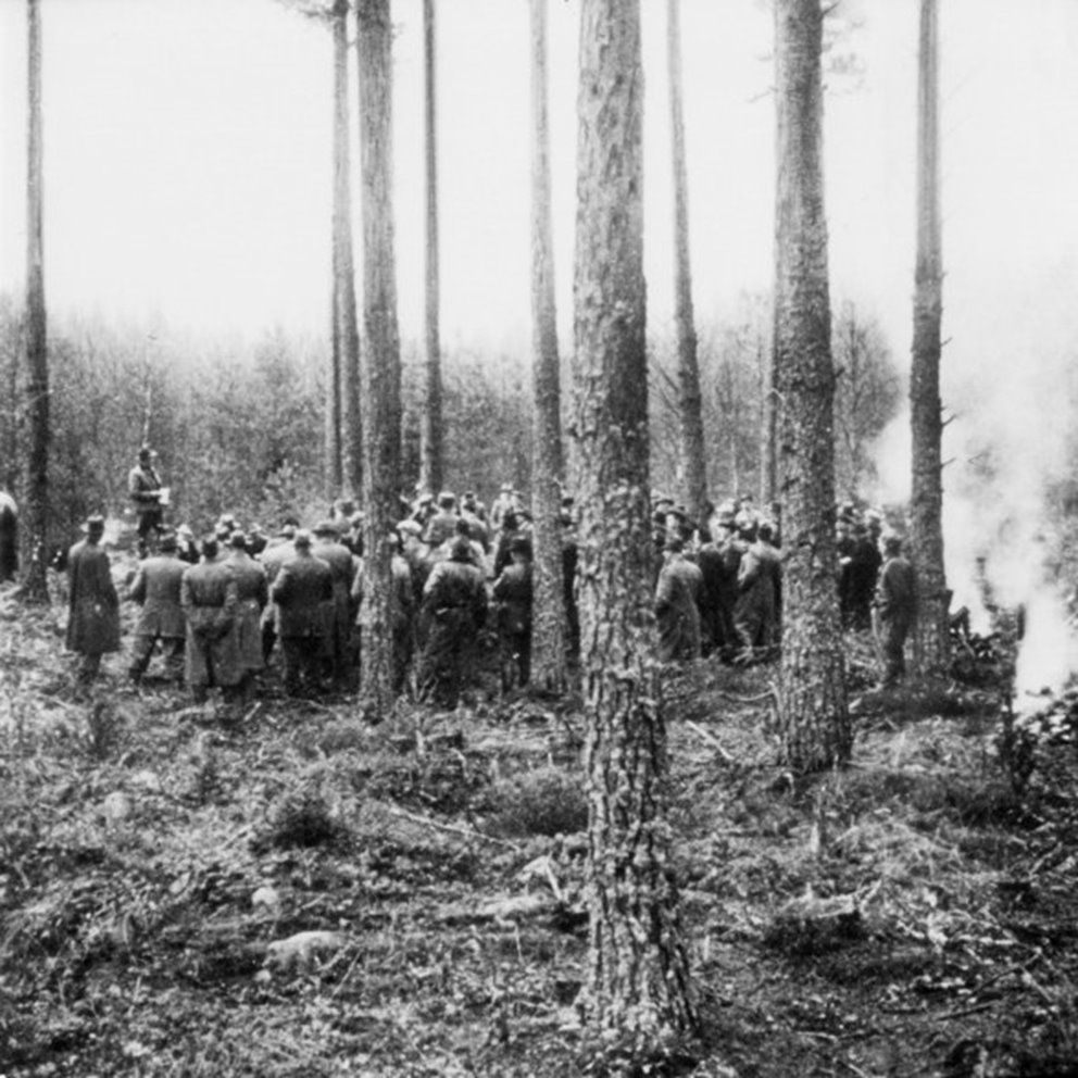Samling av personer i skogen, någon håller anförande. Omskannad _342.