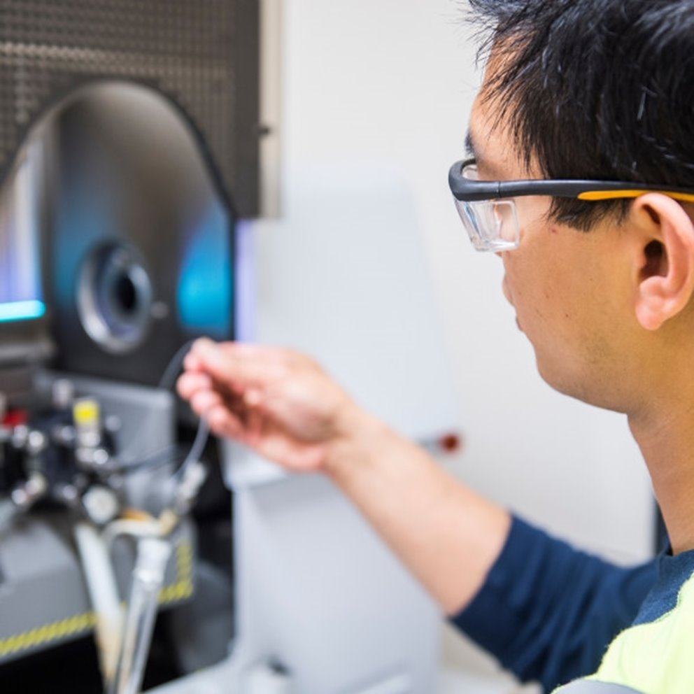 Male employee adjusting machine