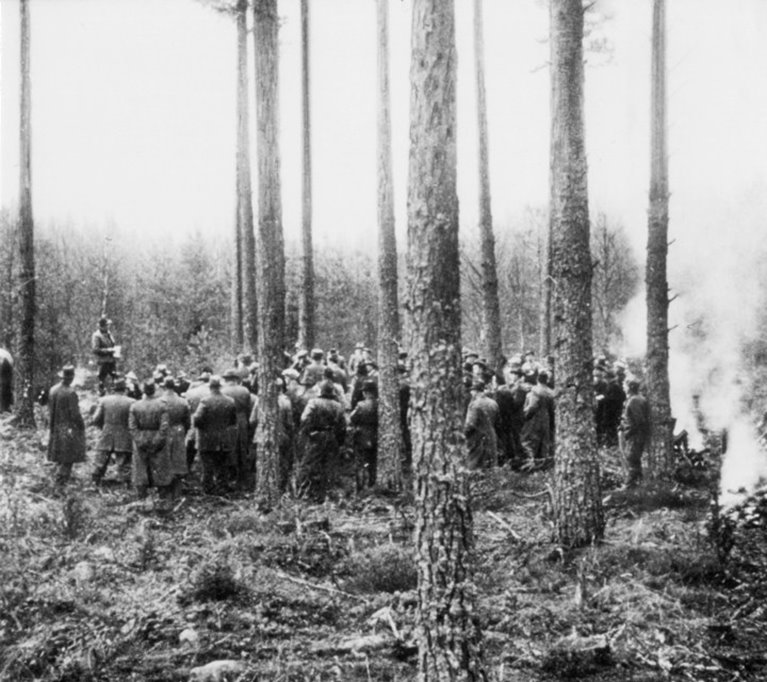 Samling av personer i skogen, någon håller anförande. Omskannad _342.