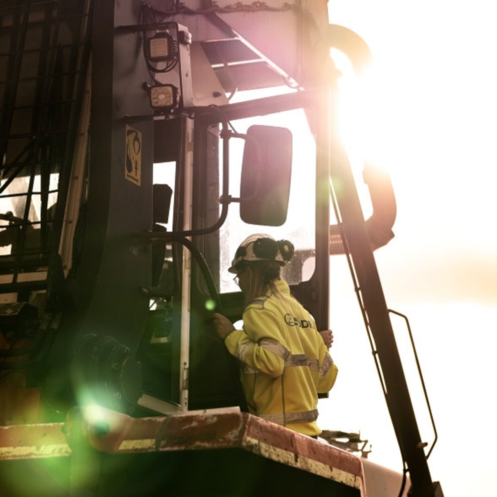 Woman in workwear entering a machine