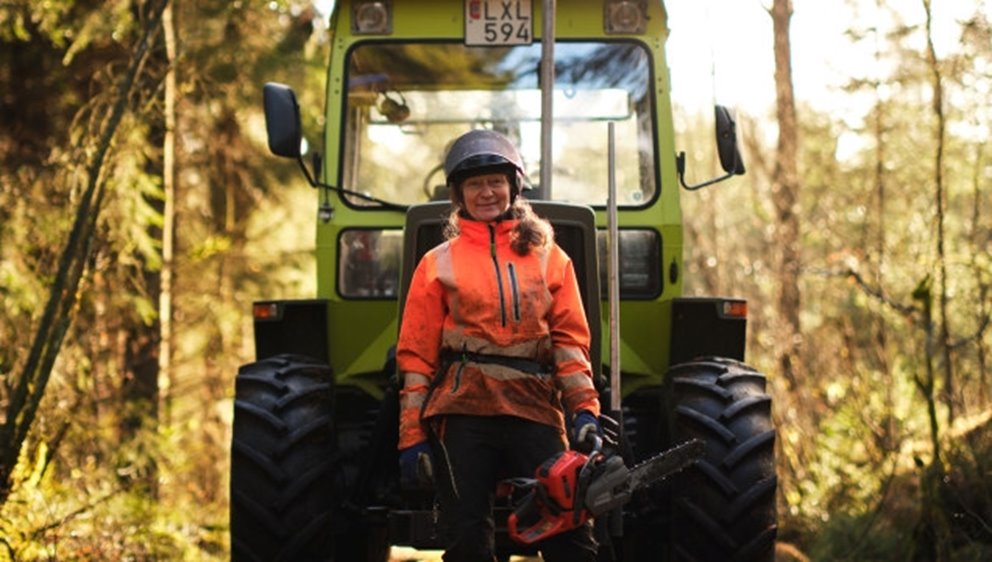 Kvinna framför traktor