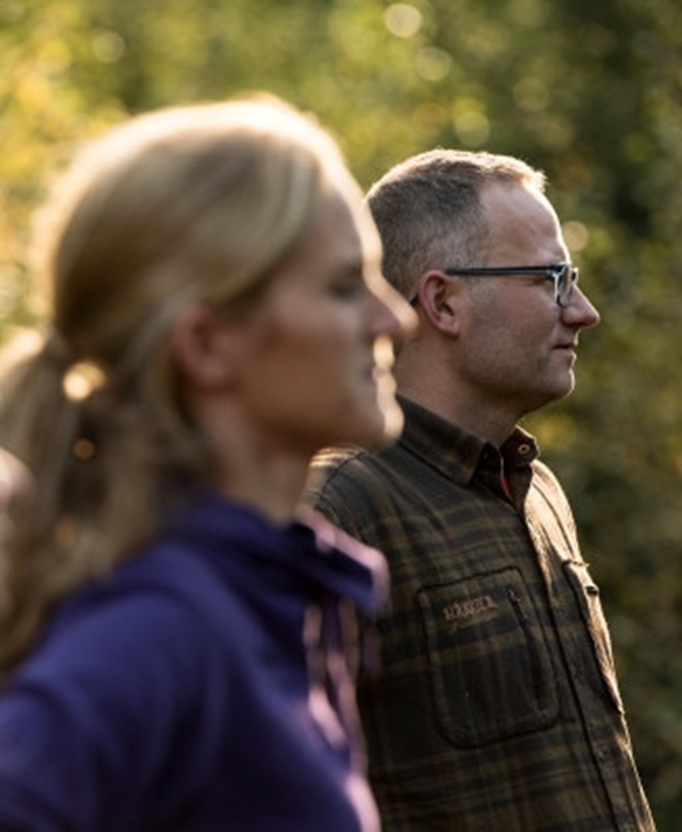 Två människor i profil på en solig dag i skogen