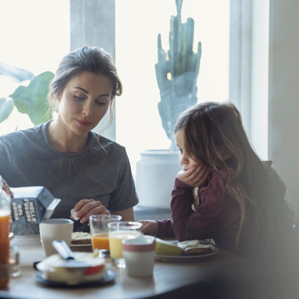 Kvinna och barn äter frukost tillsammans vid ett bord