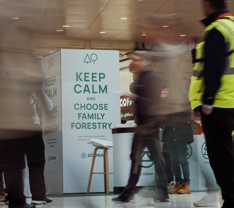 Människor i rörelse framför Södras infomartionsskylt