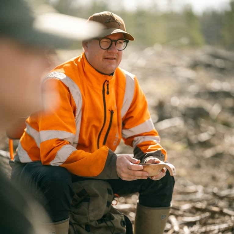 Man i varseljacka i skogsmiljö