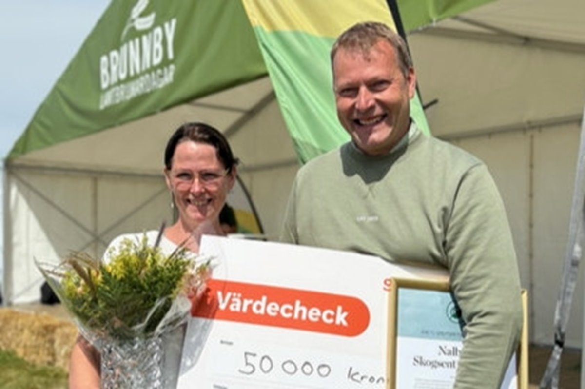 Glad kvinna och man med blommor och värdecheck