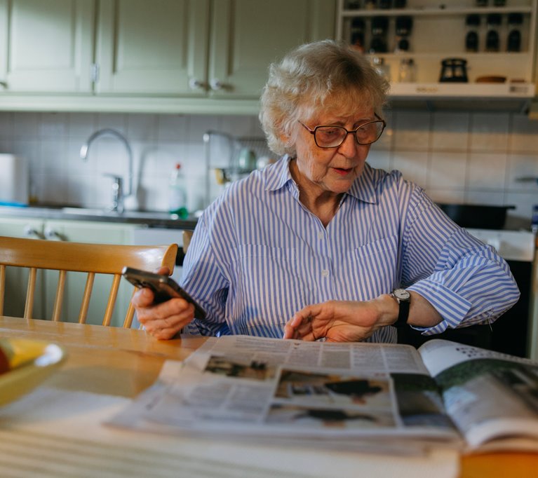Medlem Yvonne Strömgren sitter vid köksbordet och läser tidningen