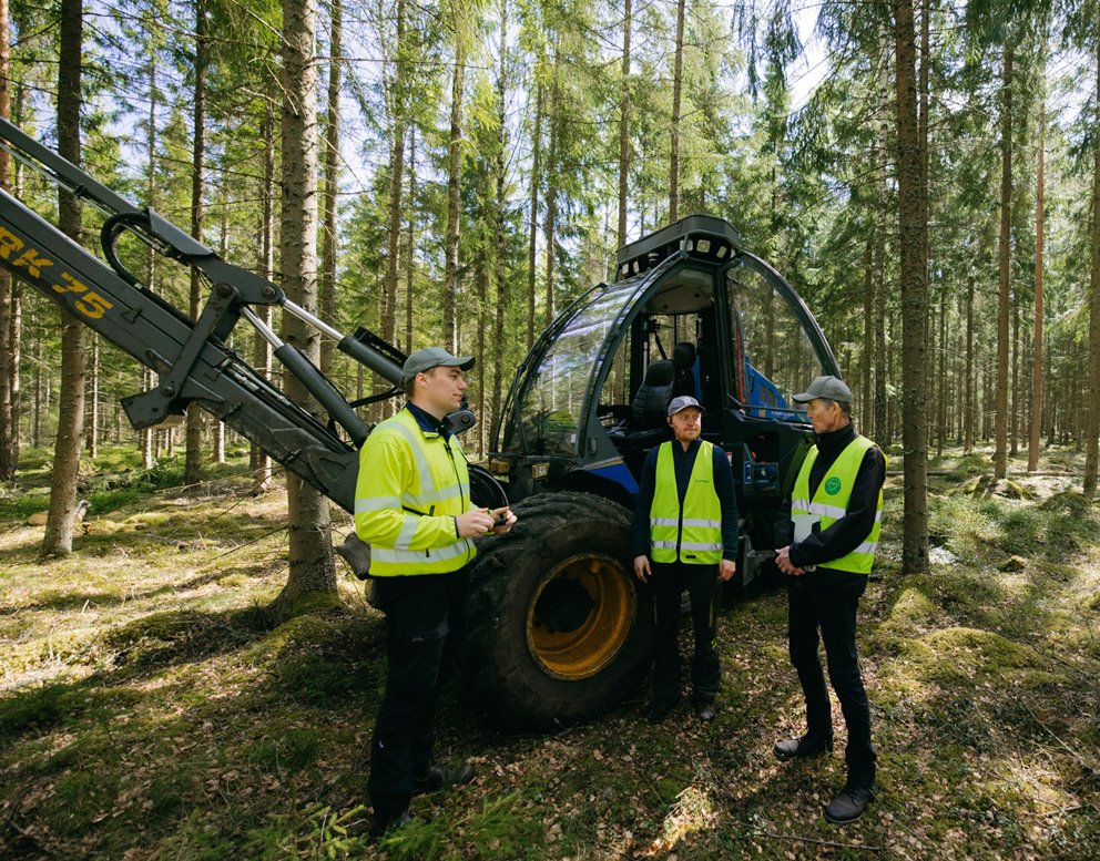 Rådgivare Simon Almén, entreprenör Johan Andersson och medlem Lars Strömgren står framför skördaren och diskuterar.