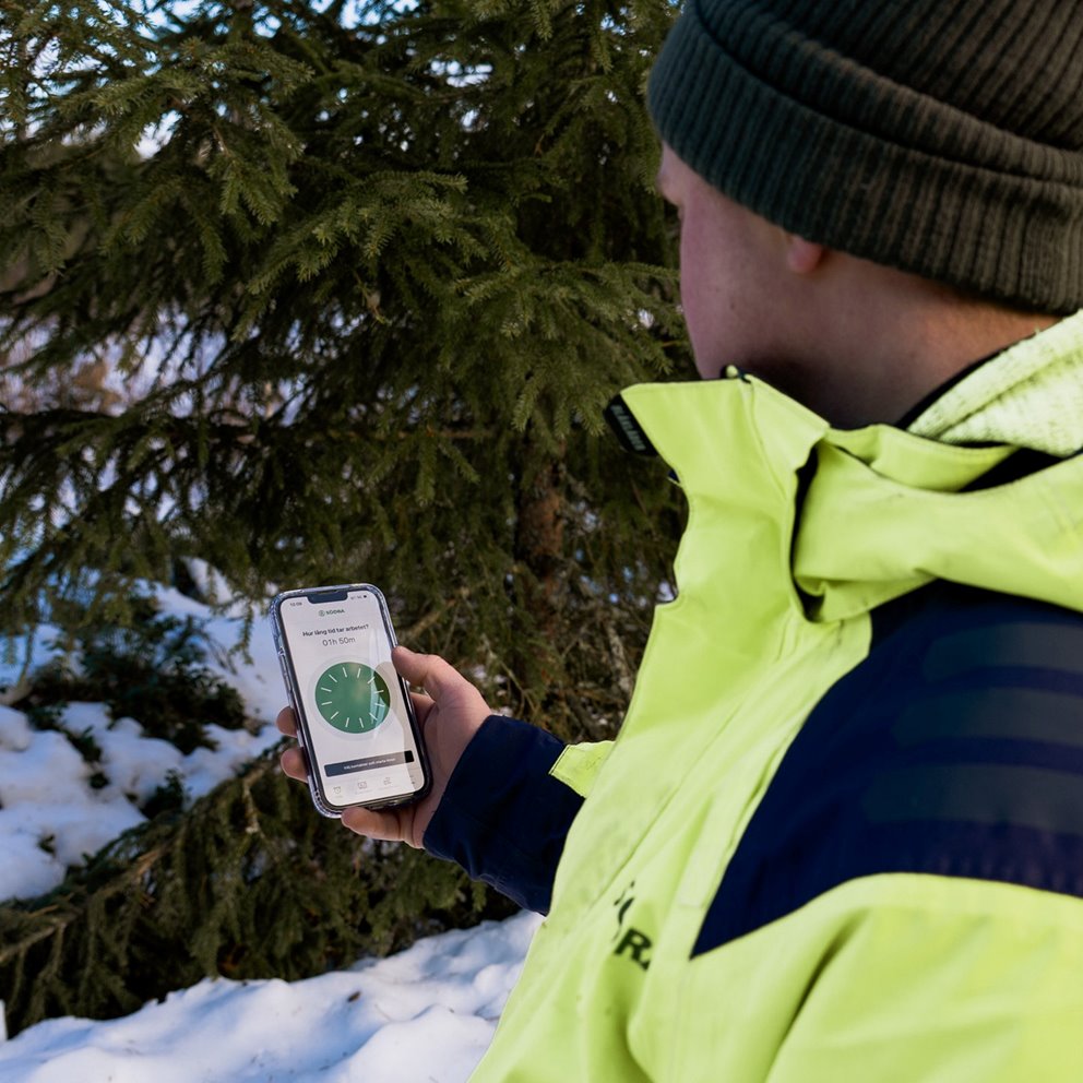 Rådgivaren Linus Olsson tittar på mobiltelefonen. Och sätter igång appen Tryggve.