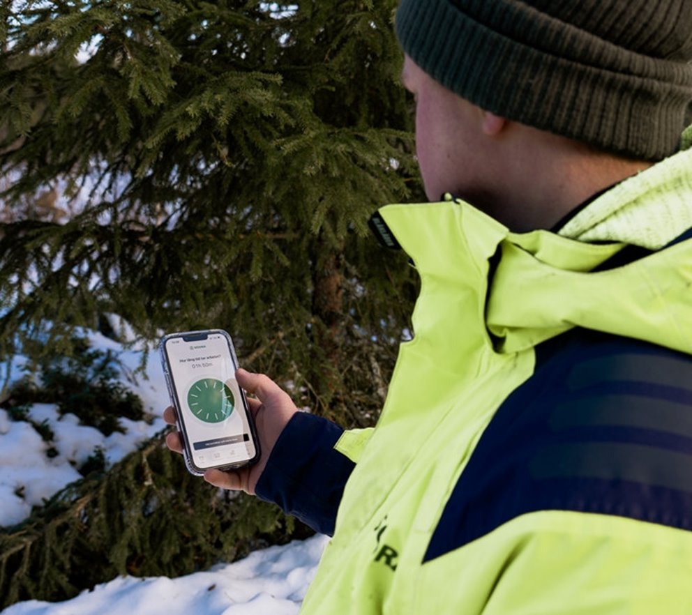 Rådgivaren Linus Olsson tittar på mobiltelefonen. Och sätter igång appen Tryggve.