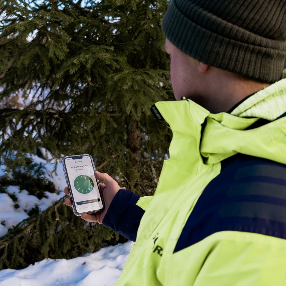 Rådgivaren Linus Olsson tittar på mobiltelefonen. Och sätter igång appen Tryggve.
