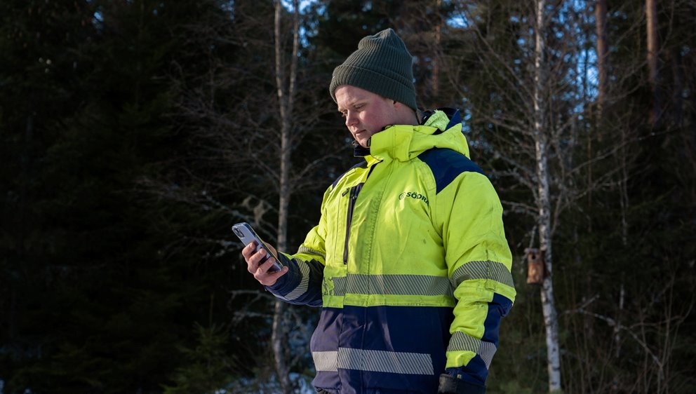 Rådgivaren Linus Olsson tittar på mobiltelefonen. Och sätter igång appen Tryggve.