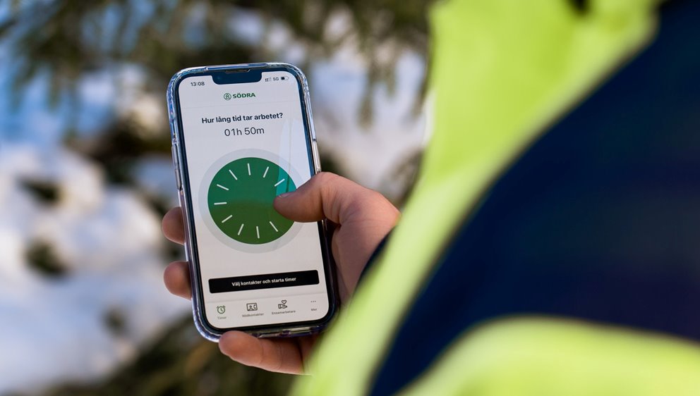 Rådgivaren Linus Olsson tittar på mobiltelefonen. Och sätter igång appen Tryggve.